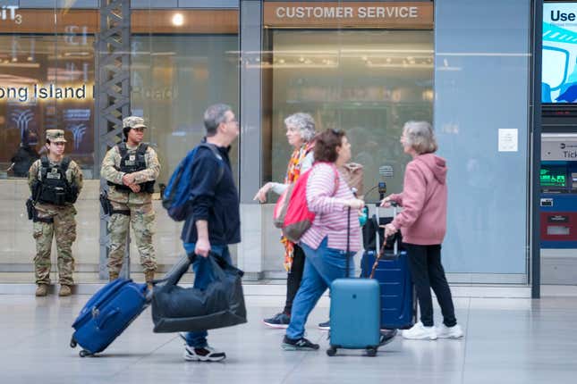 Commuters walk past a couple of New York National Guard soldiers stand guard a the Moynihan Train Hall at Penn Station, Thursday, March 7, 2024, in New York. New York Gov. Kathy Hochul announced plans Wednesday to send the National Guard to the New York City subway system to help police conduct random searches of riders&#39; bags for weapons following a series of high-profile crimes on city trains. (AP Photo/Mary Altaffer)