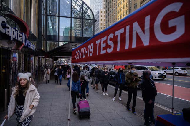 People queue to be tested for covid-19 at a street-side testing booth in New York on December 17, 2021.