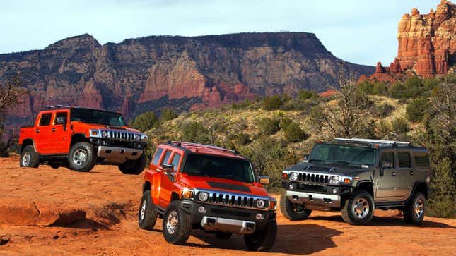 A photo of three Hummer H2 tucks parked on a mountain. 