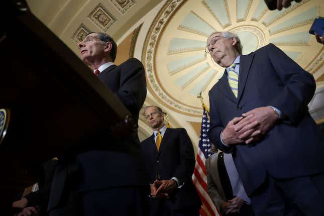 U.S. Senate Minority Leader Mitch McConnell (R-KY) (R) looks on as Sen. John Barrasso (R-WY) speaks to reporters following the weekly Republican policy luncheons, on May 03, 2022, in Washington, DC.