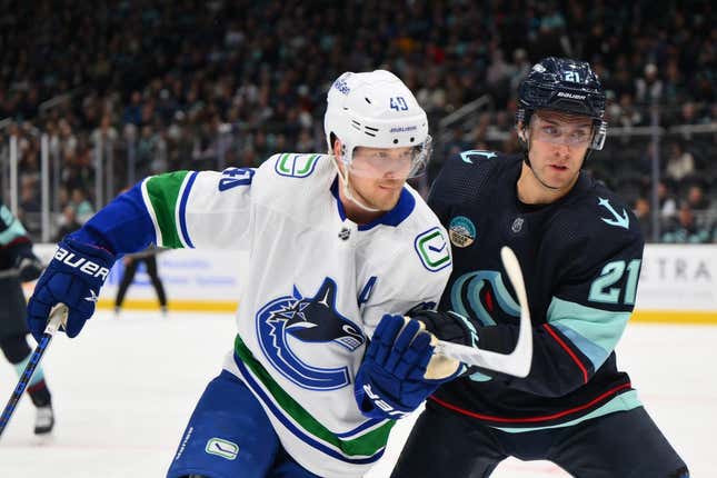 Feb 22, 2024; Seattle, Washington, USA; Vancouver Canucks center Elias Pettersson (40) and Seattle Kraken center Alex Wennberg (21) during the first period at Climate Pledge Arena.