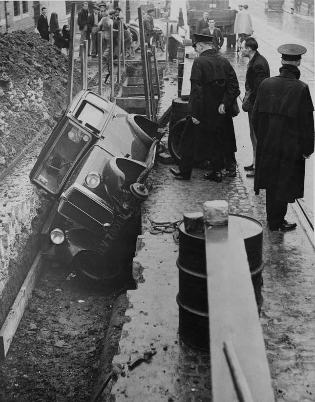 15th September 1935: A car which skidded into a trench being dug for a sewer in Crumlin Road, Belfast