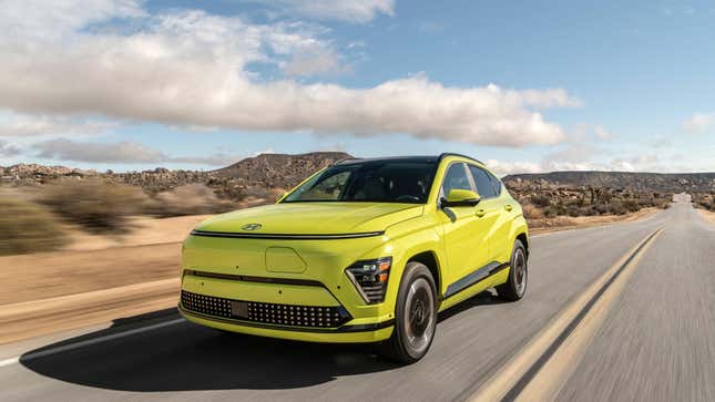 A front 3/4 view of a highlighter yellow Hyundai Kona Electric driving through the desert