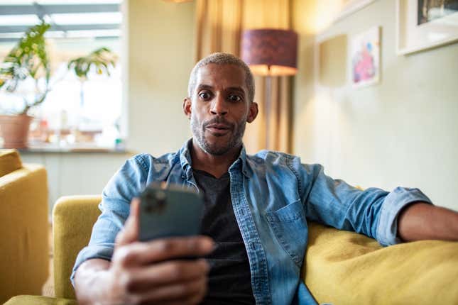 Black man staring at phone