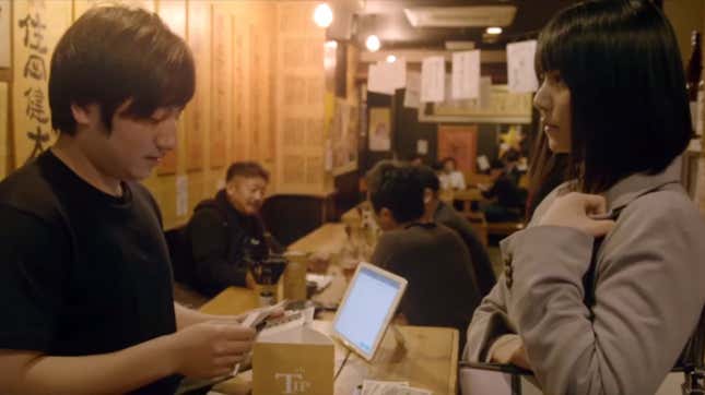 A businesswoman gives a restaurant employee a tip. 