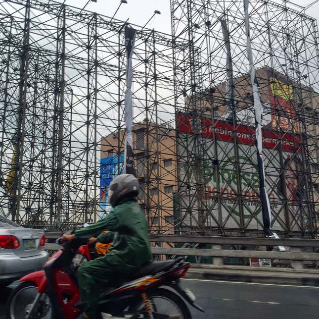 Image for article titled Photos: Dismantled billboards, ghostly scaffolds as a city braces for a typhoon