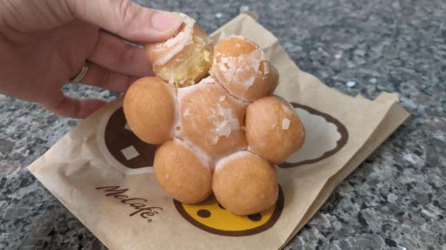 Hand pulling one donut hole off McDonald's new Glazed Pull Apart Donut