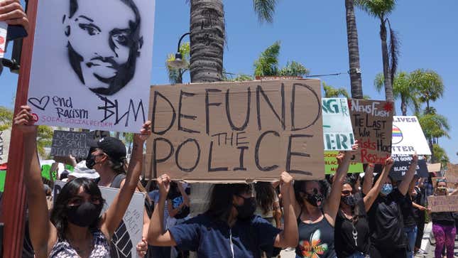 People hold signs during a peaceful Black Lives Matter protest march in Southern California on June 7, 2020.