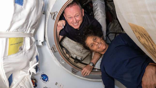 NASA's Boeing Crew Flight Test astronauts (from top) Butch Wilmore and Suni Williams pose for a portrait inside the vestibule between the forward port on the International Space Station's Harmony module and Boeing's Starliner spacecraft.