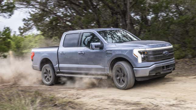 A photo of the Ford F-150 Lightning pickup truck driving on dirt. 