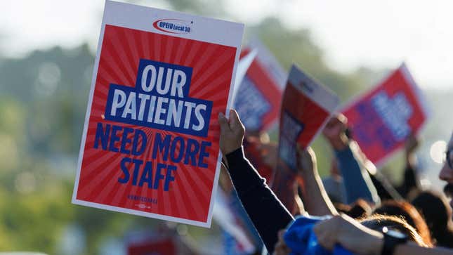 Striking Kaiser Permanente workers hold signs saying "Our patients need more staff" 