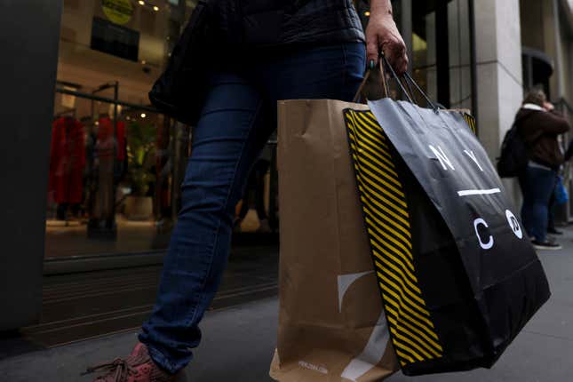 FILE - A shopper carries bags down Fifth Avenue on Nov. 25, 2022, in New York. Making returns will be more difficult this holiday season because more retailers are charging return fees, but there are ways to avoid them. Reviewing stores’ return policies before buying can mean fewer unpleasant surprises later. In some cases, joining a loyalty program can allow shoppers to avoid return fees while also offering access to early sales and exclusive offers. (AP Photo/Julia Nikhinson, File)