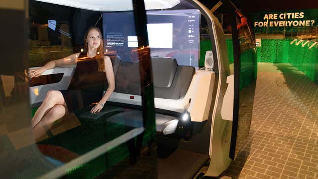 A photo of a woman sat in a VW self-driving concept car at a museum in the UK. 