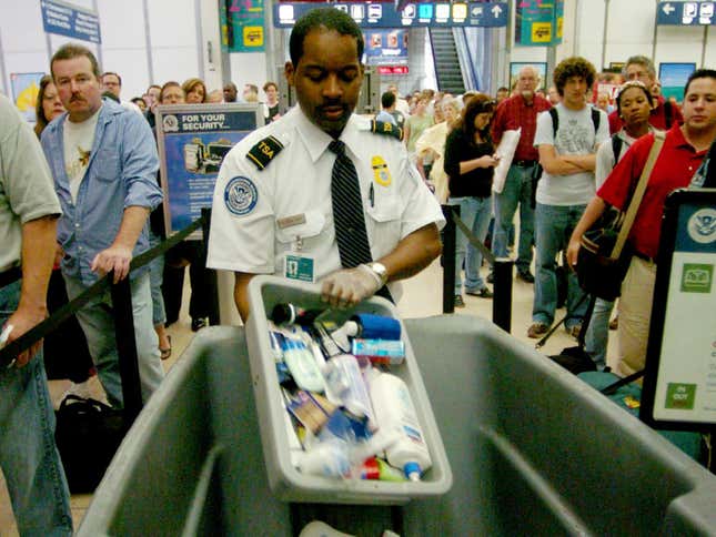 Transportation Security Administration employee Frederick Anderson trashes products collected from passengers at a security checkpoint at Chicago O’Hare International Airport in 2006