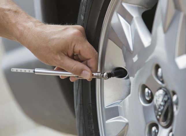 a photo of someones hand as they check a Volvo's tire pressure