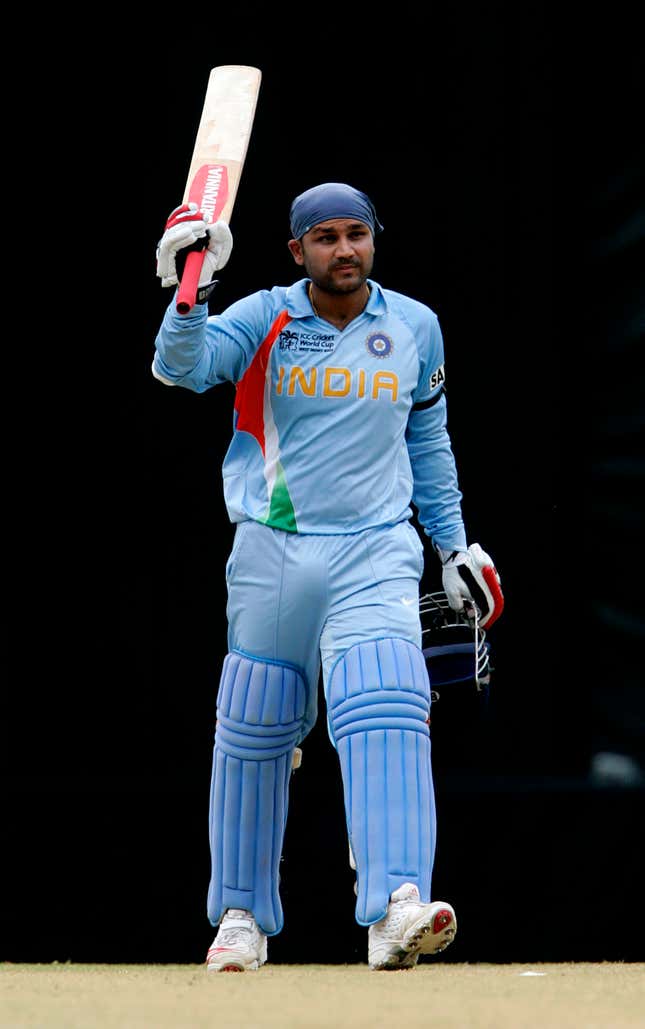 Virender Sehwag raises his bat after scoring a century during a 2007 World Cup match.