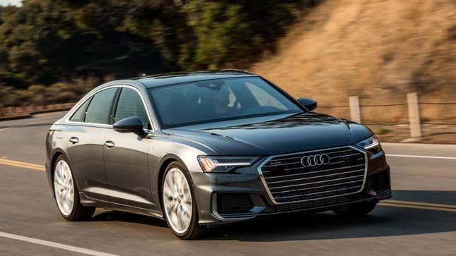 Une Audi A6 grise conduisant sur une route de montagne