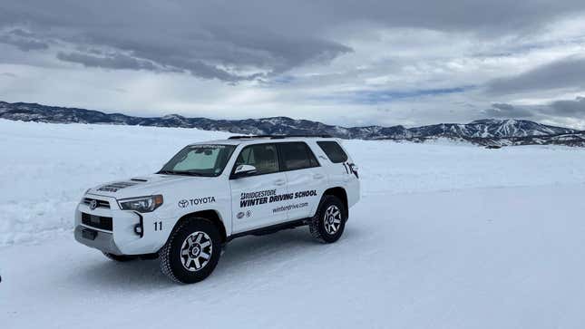 a white 4runner parked on snow with bridgestone winter driving school decals