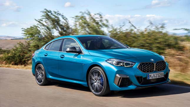 A blue BMW 2-series Gran Coupe driving in front of a bush