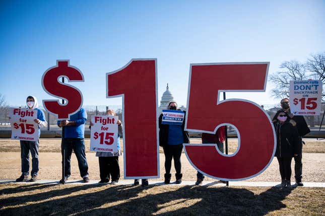 Activists with Our Revolution hold $15 minimum wage signs outside the Capitol complex on Thursday, Feb. 25, 2021, to call Congress to pass the $15 federal minimum wage hike proposed as part of the COVID relief bill.