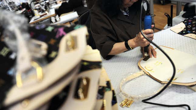 A Louis Vuitton employee works on one of the company's bags