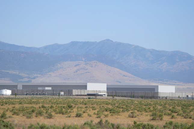 ground-level view of Meta's data center in front of mountains and a blue sky