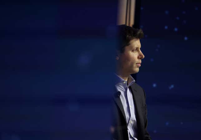 side profile of Sam Altman looking forward, he is partly hidden by a blue object