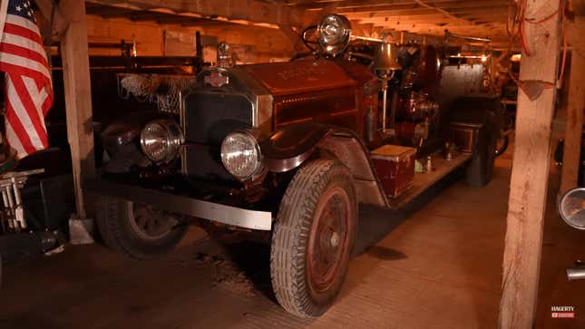 A photo of an old fire truck in a barn. 