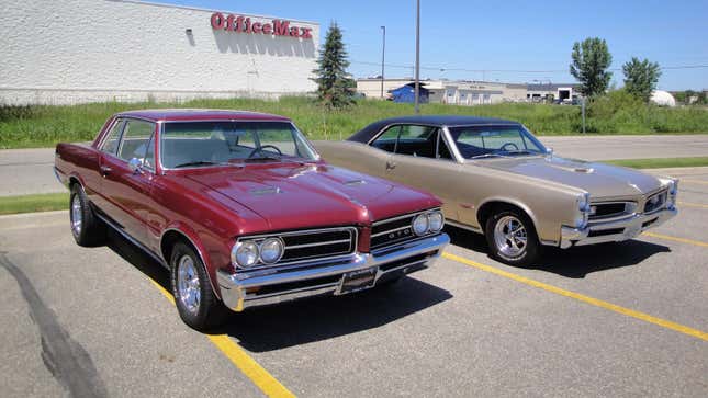 Ein roter Pontiac GTO von 1964 und ein beiger Pontiac GTO von 1966 auf einem Parkplatz.