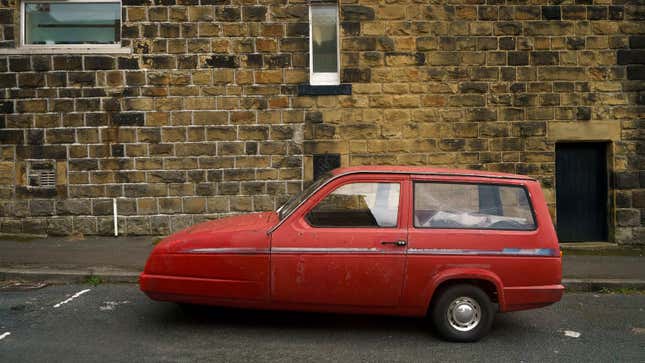 A photo of a red Reliant Robin three-wheeler. 