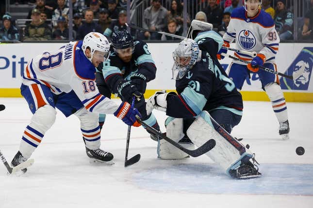 Nov 11, 2023; Seattle, Washington, USA; Edmonton Oilers left wing Zach Hyman (18) scores his second goal of the during the first period against Seattle Kraken goaltender Philipp Grubauer (31) and defenseman Adam Larsson (6)  at Climate Pledge Arena.