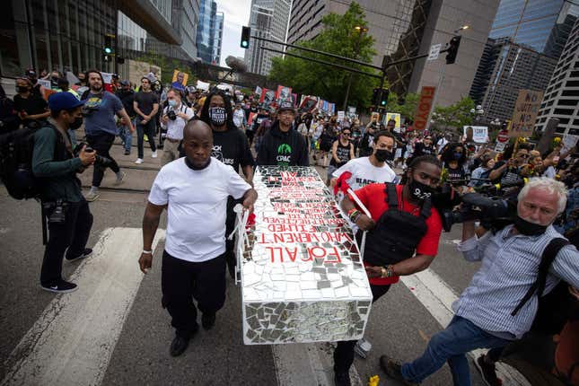 People carry a symbolic casket at a rally and march for the one-year anniversary of George Floyd’s death on Sunday, May 23 in Minneapolis, Minn. 