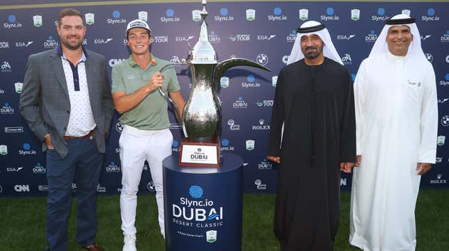 Chris Kirchner (far left) stands next to Viktor Hovland of Norway who holds his trophy at the Slync.io Dubai Desert Classic at Emirates Golf Club on January 30, 2022 in Dubai, United Arab Emirates.