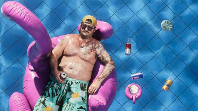 A man sits in a tube in a pool with beer cans.