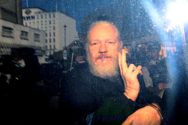 Julian Assange gestures to the media from a police vehicle on his arrival at Westminster Magistrates court on April 11, 2019 in London, England. After weeks of speculation, Wikileaks founder Julian Assange was arrested by Scotland Yard Police Officers inside the Ecuadorian Embassy in Central London this morning. Ecuador’s President, Lenin Moreno, withdrew Assange’s Asylum after seven years citing repeated violations to international conventions.