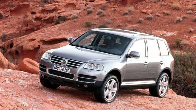 A photo of a VW Touareg parked on red rocks. 