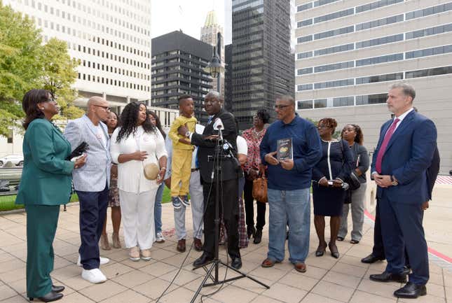 Attorney Ben Crump, center, holds Zayden Joseph, 6, the great-grandson of Henrietta Lacks, while standing with attorneys and other descendants of Lacks, whose cells have been used in medical research without her permission, outside the federal courthouse in Baltimore, Monday, Oct. 4, 2021. They announced during a news conference that Lacks’ estate is filing a lawsuit against Thermo Fisher Scientific for using Lacks’ cells, known as HeLa cells.