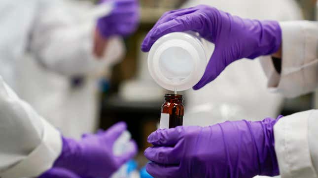 A water researcher, pours a water sample into a smaller glass container for experimentation as part of PFAS research at the EPA’s Center For Environmental Solutions and Emergency Response on Feb. 16, 2023.