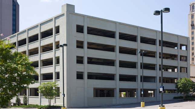 A depressing gray brick sitting known as a parking garage.