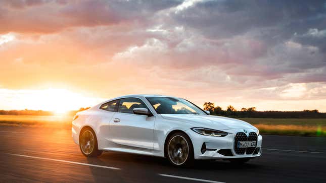 Une BMW 430i blanche roulant devant un magnifique coucher de soleil