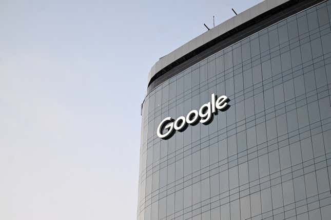 upward view of Google logo on side edge of curved glass building