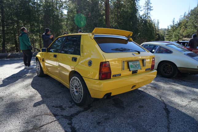 A yellow Lancia Delta Integrale is parked next to a classic Porsche 911.