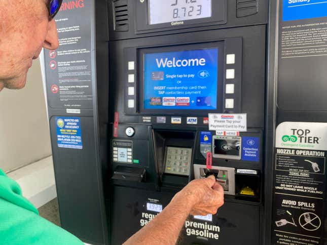 Kirkland Gas Station, West Palm Beach, Florida, Mature adult man filling tank at gas pump. 
