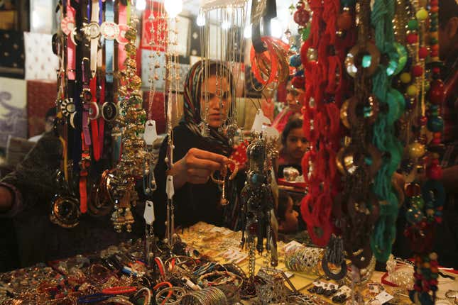 A shopper buys jewelry from a market stall in Lahore, Pakistan.
