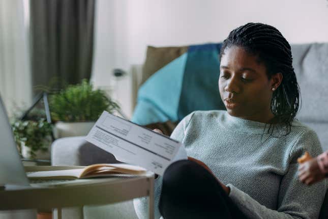 Black woman looking at bills 