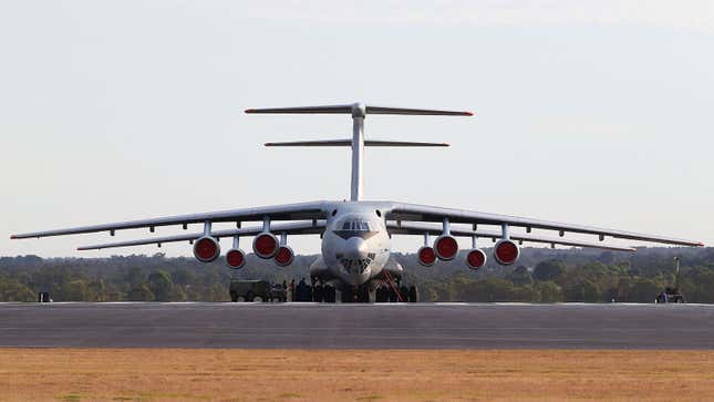 A photo of two large planes lined up on a runway. 