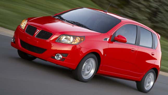 A bright red Pontiac G3 driving in front of trees