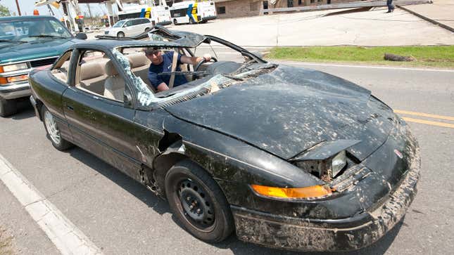 A man drives a smashed up car down the highway 