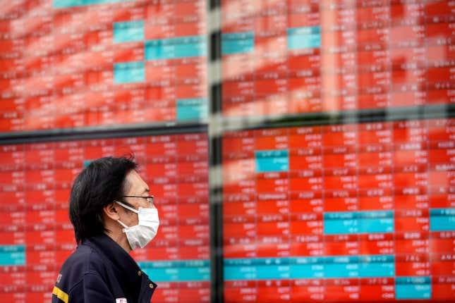 FILE - A post office worker stands in front of an electronic stock board showing Japan&#39;s Nikkei 225 index at a securities firm in Tokyo, on Nov. 6, 2023. Asian shares surged higher on Wednesday, Nov. 15 cheered by a rally on Wall Street that was one of the best days of the year following a surprisingly encouraging report on inflation. (AP Photo/Eugene Hoshiko, File)