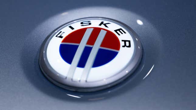 Un primer plano de una insignia de Fisker en un automóvil plateado